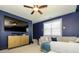Comfortable living room features a modern TV set, cabinet, neutral couch, and ceiling fan at 10944 Persimmon Creek Dr, Mint Hill, NC 28227