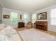 Open living room featuring hardwood floors, three windows, a piano, and comfortable seating at 10944 Persimmon Creek Dr, Mint Hill, NC 28227
