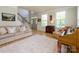 Sunlit living room with hardwood floors, a piano, comfortable seating, and an open view into the foyer at 10944 Persimmon Creek Dr, Mint Hill, NC 28227