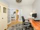 Home office with hardwood floors, a desk, and adjacent entry with French doors, offering a peek at the foyer at 10944 Persimmon Creek Dr, Mint Hill, NC 28227