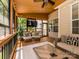 Beautiful screened porch features a ceiling fan, wooden floor, seating, and backyard view at 10944 Persimmon Creek Dr, Mint Hill, NC 28227