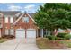 Traditional brick home featuring a well-maintained lawn, mature tree, and a two-car garage at 11329 Corliss Ave, Charlotte, NC 28277