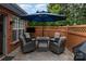 Cozy brick patio with outdoor seating, umbrella, and privacy fence at 11329 Corliss Ave, Charlotte, NC 28277
