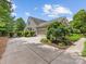 Charming home exterior with lush landscaping, a paved driveway, and a two-car garage at 11727 Dunham Dr, Matthews, NC 28105