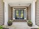 Inviting front entrance with decorative glass double doors and stone accents at 11727 Dunham Dr, Matthews, NC 28105