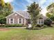 Attractive single-Gathering home with stone detailing, bright windows, and a neatly landscaped front yard at 11727 Dunham Dr, Matthews, NC 28105