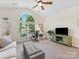 Bright living room with vaulted ceiling, fan, large window, desk, and entertainment center at 11727 Dunham Dr, Matthews, NC 28105