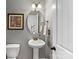 Charming powder room with pedestal sink, decorative mirror, and soft lighting at 11727 Dunham Dr, Matthews, NC 28105