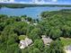 Stunning aerial view of a home surrounded by lush trees and a lake at 128 Spears Creek Dr, Mooresville, NC 28117