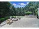 Well-manicured backyard featuring a stone fire pit and grill station at 128 Spears Creek Dr, Mooresville, NC 28117