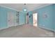 Bedroom in vibrant blue with plush carpet, a modern light fixture and built-in shelving at 128 Spears Creek Dr, Mooresville, NC 28117