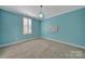 Bedroom in vibrant blue, complete with plush carpet, shuttered windows, and a stylish light fixture at 128 Spears Creek Dr, Mooresville, NC 28117