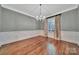 Formal dining room with elegant wainscoting, hardwood floors, and a stylish chandelier at 128 Spears Creek Dr, Mooresville, NC 28117