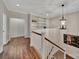 Upstairs hallway with hardwood floors, a built-in bookshelf, and decorative lighting at 128 Spears Creek Dr, Mooresville, NC 28117