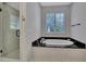 Bright bathroom with a soaking tub, large window with shutters, and glass shower at 128 Spears Creek Dr, Mooresville, NC 28117