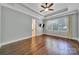 Bright main bedroom featuring a tray ceiling, ceiling fan, and hardwood floors at 128 Spears Creek Dr, Mooresville, NC 28117
