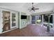 A spacious screened-in porch featuring a ceiling fan, wall-mounted TV, and sliding doors at 128 Spears Creek Dr, Mooresville, NC 28117