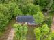 Aerial view of the cozy home surrounded by large trees with a driveway and front porch at 131 Little Forest Ln, Statesville, NC 28625