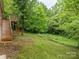 Large backyard featuring a wood staircase and deck is surrounded by mature trees and vegetation at 131 Little Forest Ln, Statesville, NC 28625