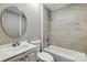 Well-lit bathroom features a tile surround shower and tub combination, large vanity, and modern round mirror at 131 Little Forest Ln, Statesville, NC 28625