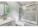 Bathroom featuring a tub with tile surround, glass door, toilet, and modern vanity at 131 Little Forest Ln, Statesville, NC 28625