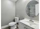Bathroom featuring a round mirror, toilet, and modern vanity at 131 Little Forest Ln, Statesville, NC 28625