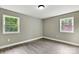 Bedroom with light walls, two windows providing ample natural light, and hardwood floors at 131 Little Forest Ln, Statesville, NC 28625