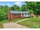 A charming home featuring a brick and siding exterior, a lush green lawn, and a cozy front porch at 131 Little Forest Ln, Statesville, NC 28625