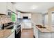The kitchen features stainless steel appliances, granite countertops, a kitchen island and mosaic backsplash at 131 Little Forest Ln, Statesville, NC 28625