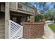Charming condo featuring a covered patio with seating, brick accents, and lush landscaping at 1608 Sharon W Rd # 55, Charlotte, NC 28210