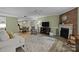Comfortable living room with exposed brick fireplace, chair, and view into dining area at 1608 Sharon W Rd # 55, Charlotte, NC 28210