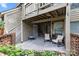 Charming covered patio area with comfortable seating, brick accents, and lush landscaping at 1608 Sharon W Rd # 55, Charlotte, NC 28210