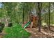 This backyard has a large playset, a deck and patio and a seating area with a fire pit at 1614 Tarrington Way, Indian Trail, NC 28079