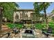The backyard has a stone fire pit surrounded by Adirondack chairs, a deck and a brick home at 1614 Tarrington Way, Indian Trail, NC 28079