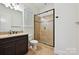 Elegant bathroom features a granite countertop, framed glass shower, and window at 1614 Tarrington Way, Indian Trail, NC 28079