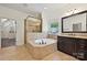 Bathroom featuring a soaking tub, granite countertops, and glass shower at 1614 Tarrington Way, Indian Trail, NC 28079