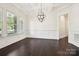 Formal dining room with a coffered ceiling, modern chandelier, hardwood floors, and wainscoting at 1614 Tarrington Way, Indian Trail, NC 28079