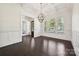 Open dining room with hardwood floors, white trim, pendant lighting, and large windows bringing in natural light at 1614 Tarrington Way, Indian Trail, NC 28079