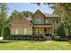 Beautiful, two-story brick and stone home featuring a landscaped front yard, covered porch, and meticulous shrubbery at 1614 Tarrington Way, Indian Trail, NC 28079