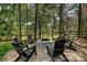 A stone fire pit sits in a backyard seating area, surrounded by tall trees and string lights at 1614 Tarrington Way, Indian Trail, NC 28079