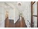 Bright hallway featuring hardwood floors, white wainscoting, crown molding, and paneled glass doors at 1614 Tarrington Way, Indian Trail, NC 28079