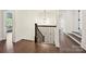 Hallway with dark hardwood floors, elegant railing, and natural light at 1614 Tarrington Way, Indian Trail, NC 28079