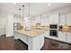 Spacious kitchen features an island with granite countertops, stainless appliances, and stylish pendant lighting at 1614 Tarrington Way, Indian Trail, NC 28079