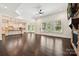 Open living room with hardwood floors, white trim, many windows, and an open kitchen area at 1614 Tarrington Way, Indian Trail, NC 28079