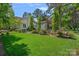 Lush backyard featuring a beautiful lawn, landscaping, mature trees, and outdoor kitchen at 17924 River Ford Dr, Davidson, NC 28036
