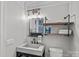 Chic bathroom with a modern concrete sink, industrial-style lighting, and open shelving for storage at 17924 River Ford Dr, Davidson, NC 28036