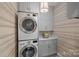 Efficient laundry room with stackable washer and dryer, gray cabinetry, and stylish patterned flooring at 17924 River Ford Dr, Davidson, NC 28036