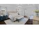 A spacious main bedroom suite has a sitting area, elegant chandelier, and ensuite bath at 17924 River Ford Dr, Davidson, NC 28036