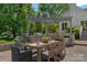 This covered outdoor kitchen boasts stone counters, stainless grill and dining table at 17924 River Ford Dr, Davidson, NC 28036