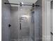 Contemporary shower featuring sleek gray subway tile, frameless glass door and pebble mosaic floor at 17924 River Ford Dr, Davidson, NC 28036
